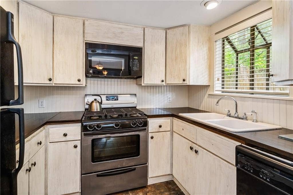 5936 Bryan Parkway, #B, Dallas, TX 75206 Kitchen featuring wood-finish cabinetry, stainless steel gas range, built-in microwave, dual-basin sink with gooseneck faucet, and beadboard backsplash