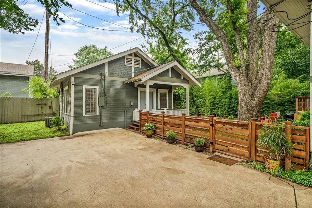 5936 Bryan Parkway, #B, Dallas, TX 75206 Exterior featuring horizontal lap siding, a gabled roofline, a covered front porch, a concrete parking area, and a horizontal wood-slat fence