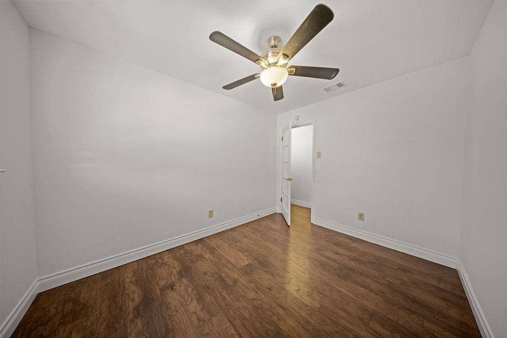 738 Intrepid Drive, Garland, TX 75043 Room featuring dark wood-finish flooring, white walls, and a ceiling-mounted fan with integrated light fixture