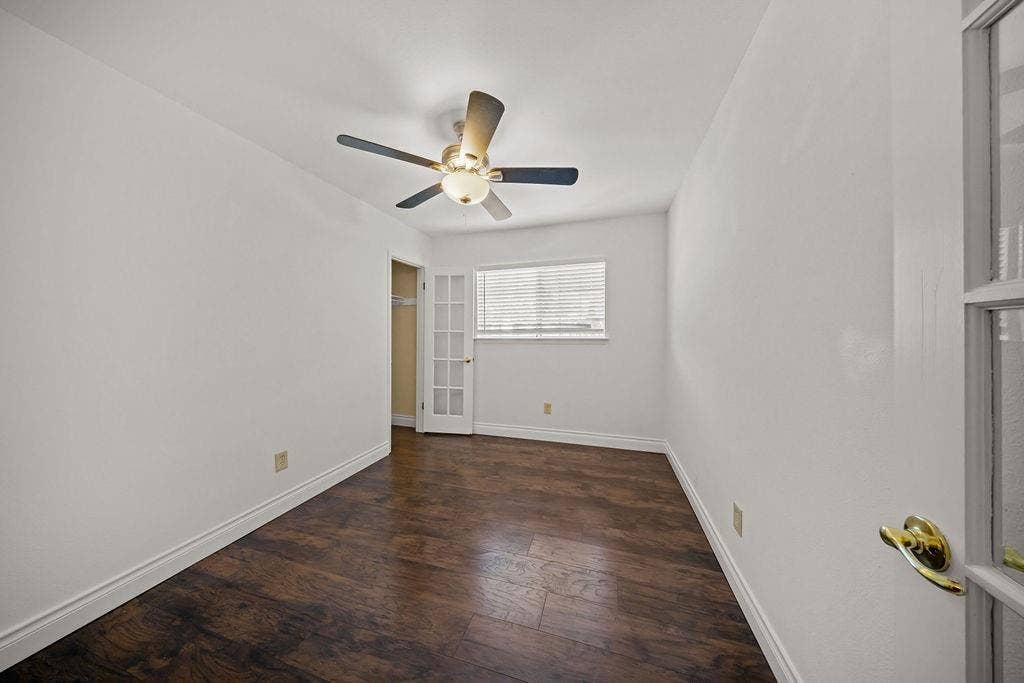 738 Intrepid Drive, Garland, TX 75043 Room featuring wood-finish flooring, a ceiling fan with integrated lighting, a multi-pane glass door, and a window with horizontal blinds