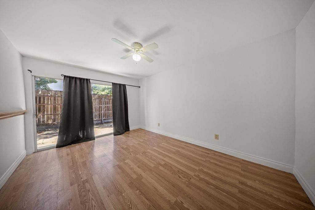 738 Intrepid Drive, Garland, TX 75043 Wood-finish flooring, sliding glass door, and a ceiling-mounted light fixture with fan