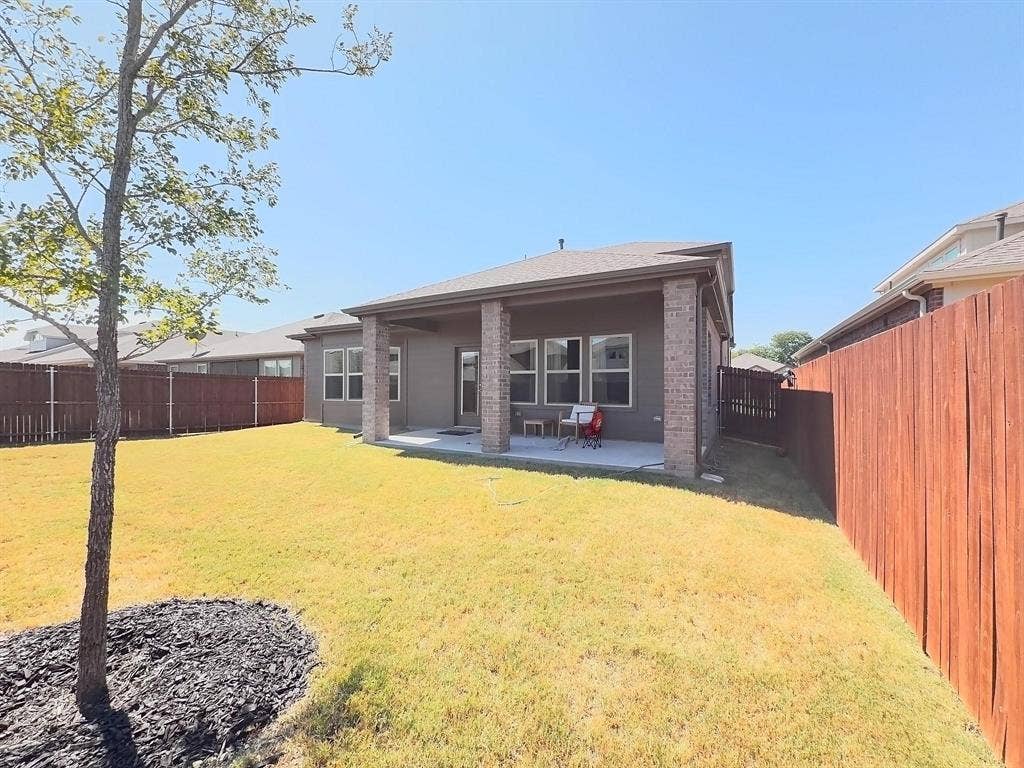 7400 Seton Place, McKinney, TX 75071 Covered back patio with masonry columns, expansive lawn, and full wood privacy fencing