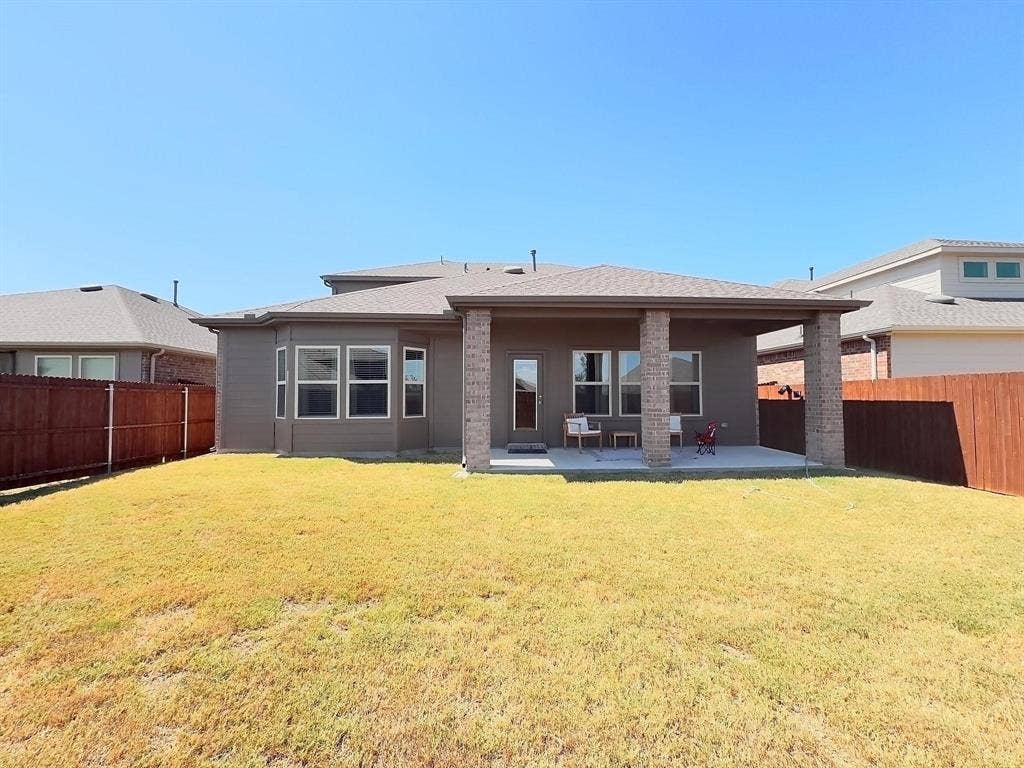 7400 Seton Place, McKinney, TX 75071 Backyard featuring a covered patio, stone-veneer support columns, concrete slab, and wood privacy fencing
