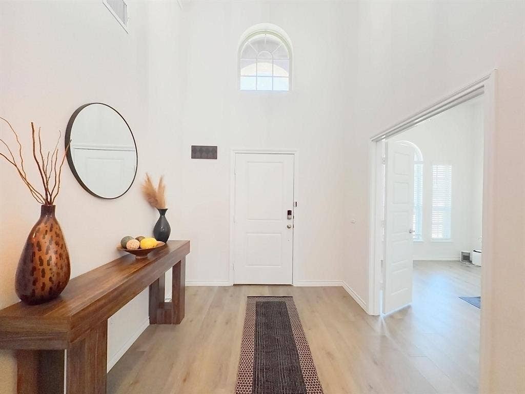 7400 Seton Place, McKinney, TX 75071 Foyer featuring high ceilings, wood-finish flooring, an arched window, and a multi-panel interior door