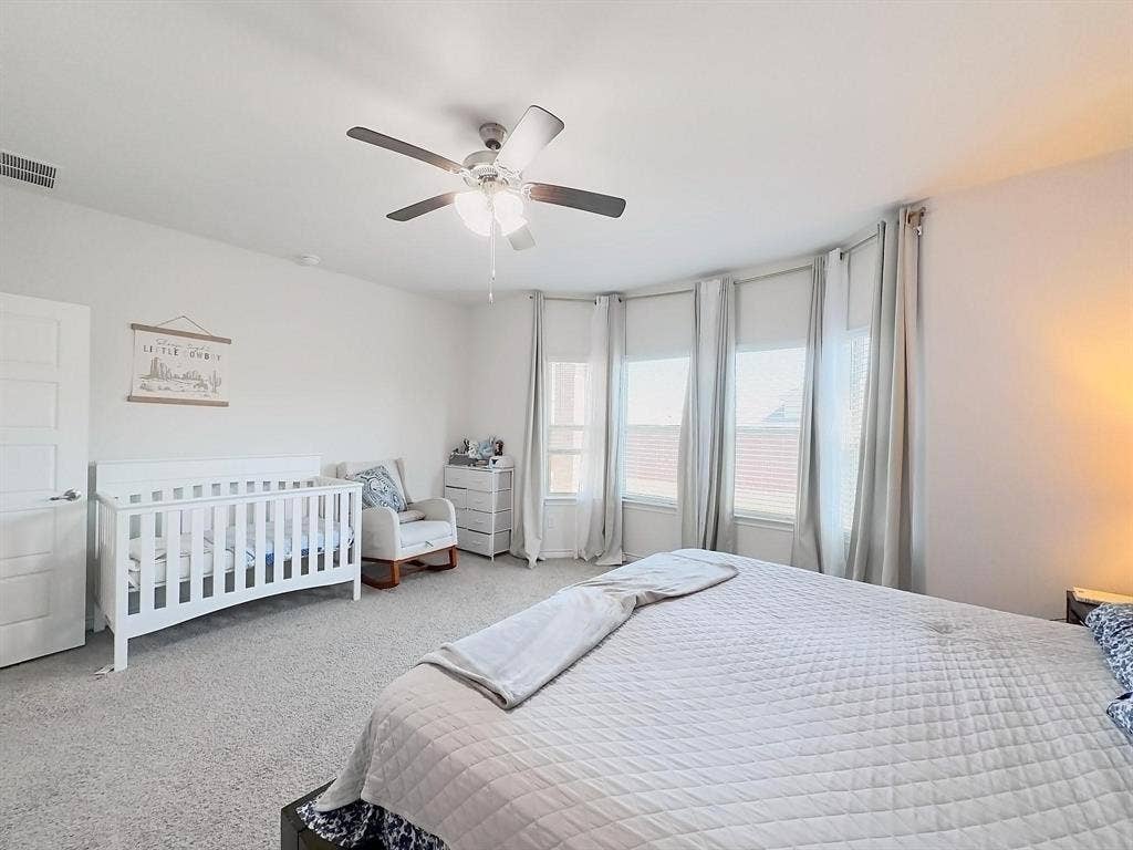 7400 Seton Place, McKinney, TX 75071 Neutral-toned interior featuring wall-to-wall carpeting, a multi-window bay configuration, and a central ceiling fan with integrated lighting