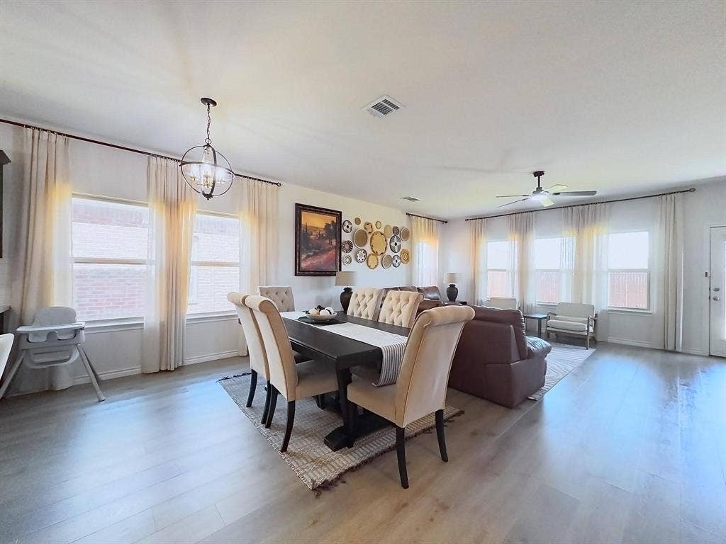 7400 Seton Place, McKinney, TX 75071 Open-concept area featuring wood-finish flooring, recessed lighting, a modern spherical chandelier, a ceiling fan, and multiple large windows