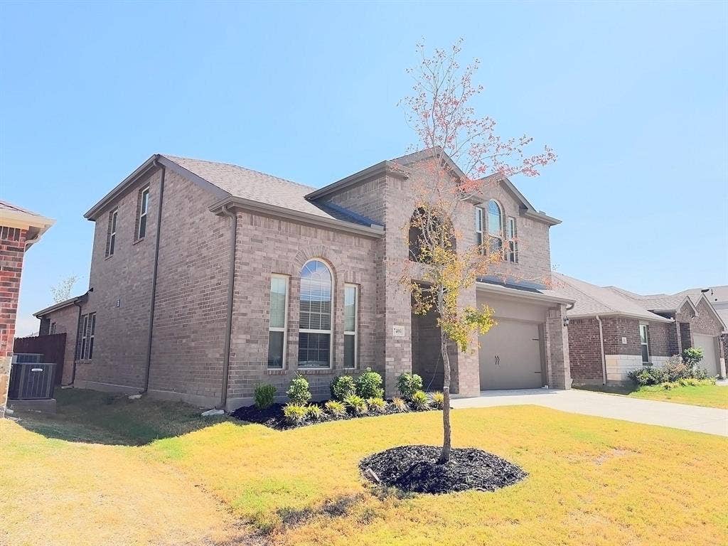 7400 Seton Place, McKinney, TX 75071 Two-story brick exterior featuring an arched entryway, arched window accents, and an attached two-car garage