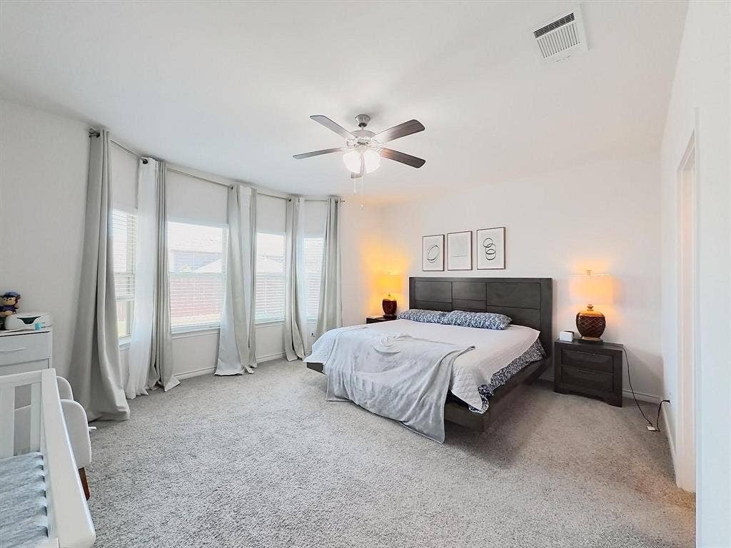 7400 Seton Place, McKinney, TX 75071 Spacious room featuring a bay window, neutral carpeting, and a ceiling fan with integrated lighting