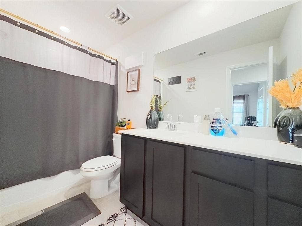 7400 Seton Place, McKinney, TX 75071 Bathroom featuring a dark-finish cabinetry vanity, white countertop with an integrated sink, polished chrome faucet, and a large wall-mounted mirror