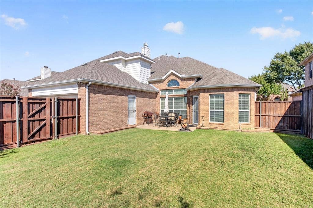 10657 Coach House Lane, Frisco, TX 75035 Wide backyard view with a grassy lawn, wood privacy fence and space to enjoy the outdoors.