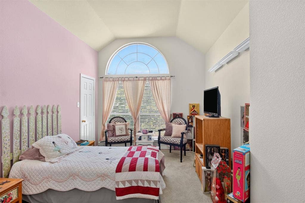 10657 Coach House Lane, Frisco, TX 75035 Bedroom with a vaulted ceiling and a tall arched window.
