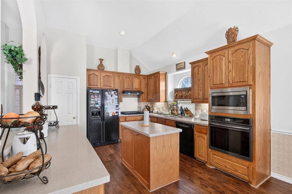 10657 Coach House Lane, Frisco, TX 75035 Alternate kitchen view highlights the gas cooktop, built-in ovens and island.