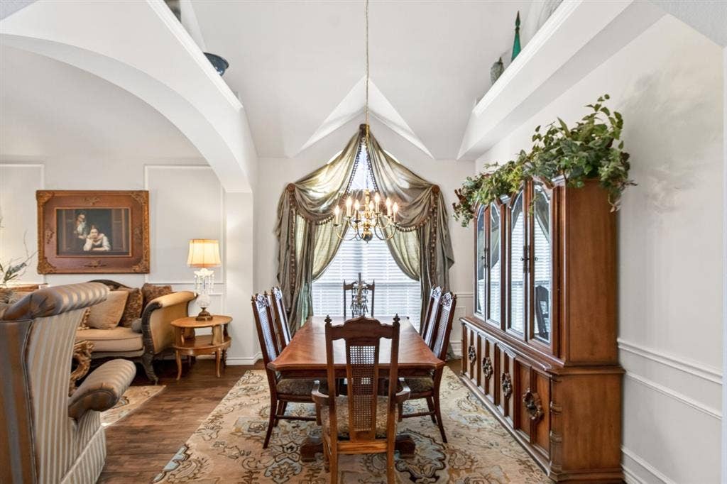 10657 Coach House Lane, Frisco, TX 75035 Dining area with a chandelier and a large window overlooking the front of the home.