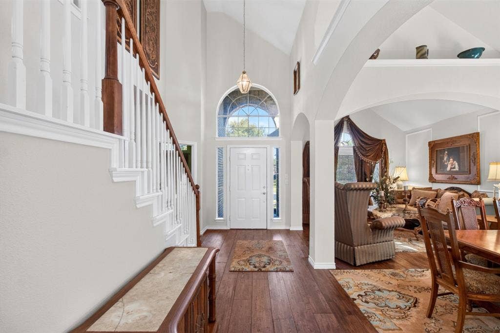 10657 Coach House Lane, Frisco, TX 75035 Bright entry with a tall arched window and an open staircase.