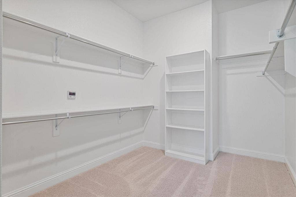 2817 Yarmouth Street, Celina, TX 75009 Walk-in storage area featuring wall-to-wall carpeting, stacked open shelving, and multi-tier metal clothing rods