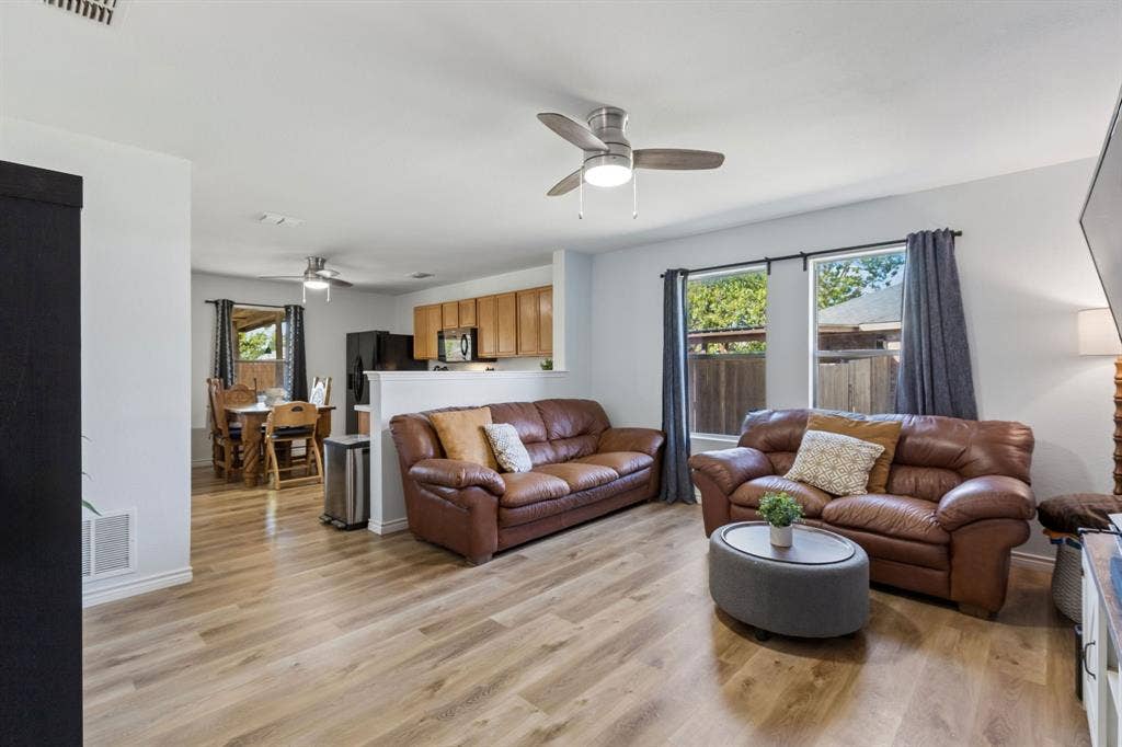 Welcome to the spacious living room. Featuring, LVP flooring, updated ceiling fan and large windows giving off lots of natural light.