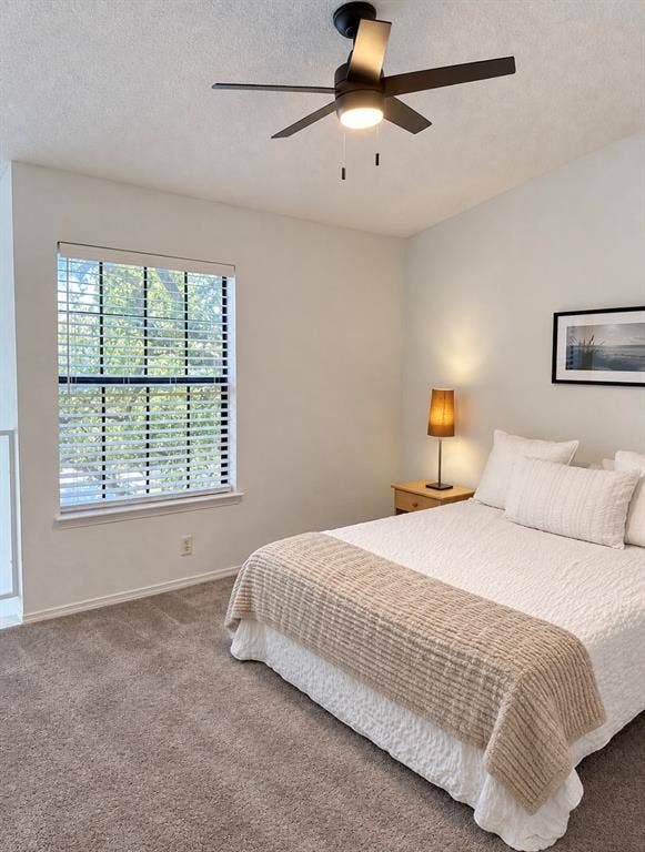 Primary bedroom offers the perfect getaway upstairs with an en-suite bathroom, large walk in closet, ceiling fan and a view of the mature trees outdoors!