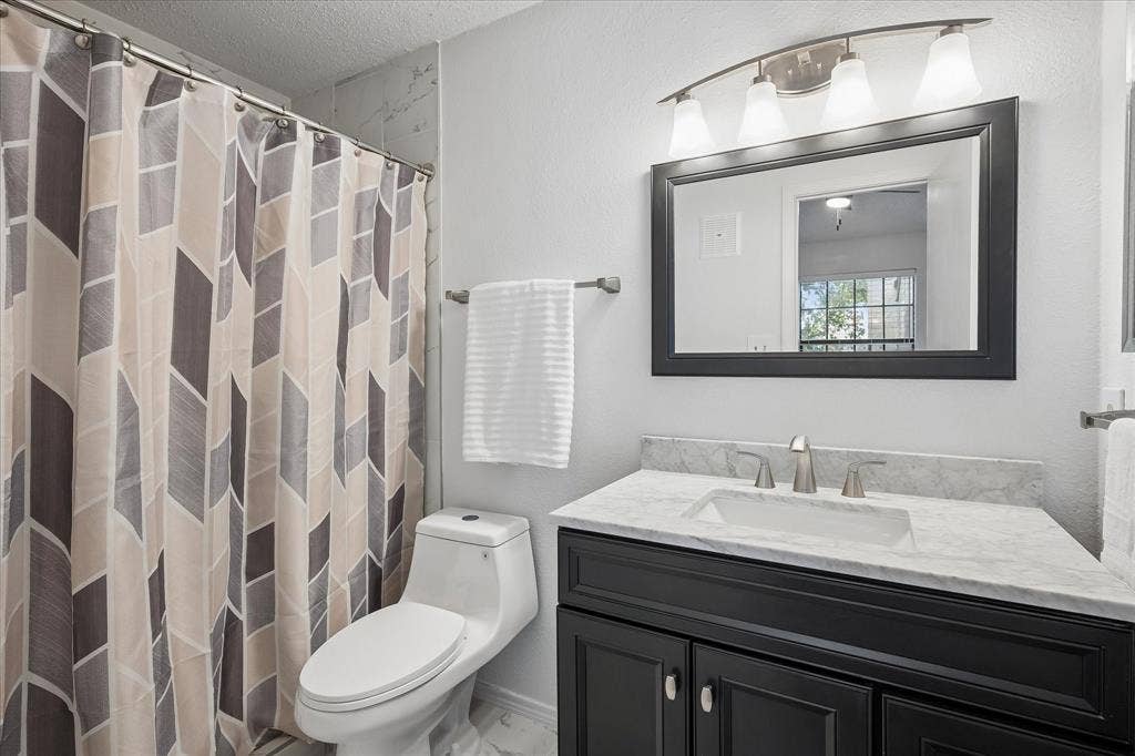 Primary bathroom has medicine cabinet and has a crisp look with all its great updates.
