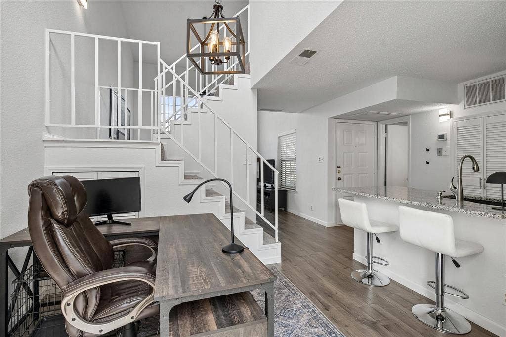 View of the front door, kitchen, staircase and living area.