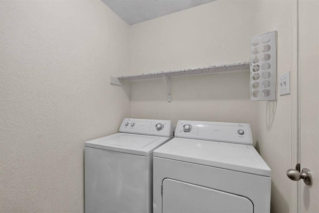 3107 Westview Drive, McKinney, TX 75070 Dedicated laundry alcove featuring white top-load washer and dryer, mounted storage shelving, and wall-affixed lighting fixture