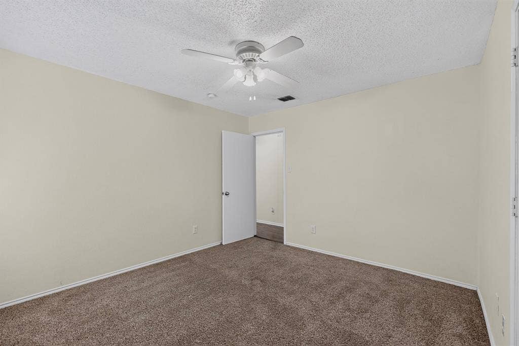 3107 Westview Drive, McKinney, TX 75070 Neutral wall finishes, textured ceiling, wall-to-wall carpeting, and a multi-blade ceiling fan with integrated lighting
