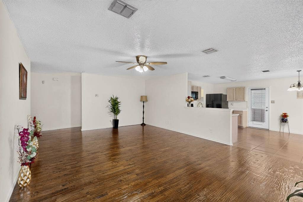 3107 Westview Drive, McKinney, TX 75070 Open floor plan featuring wood-finish flooring, neutral wall paint, recessed ceiling lighting, a ceiling fan with integrated light fixture, and ceramic tile flooring in the kitchen area
