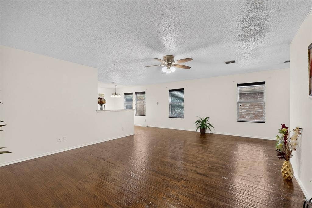 3107 Westview Drive, McKinney, TX 75070 Open-concept interior featuring wood-finish flooring, a ceiling fan with integrated lighting, and multiple windows