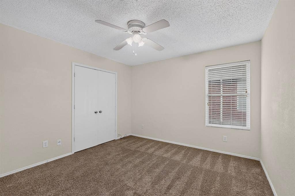 3107 Westview Drive, McKinney, TX 75070 Neutral-toned interior featuring wall-to-wall carpeting, dual-door closet, ceiling fan with integrated light fixture, and window with horizontal blinds