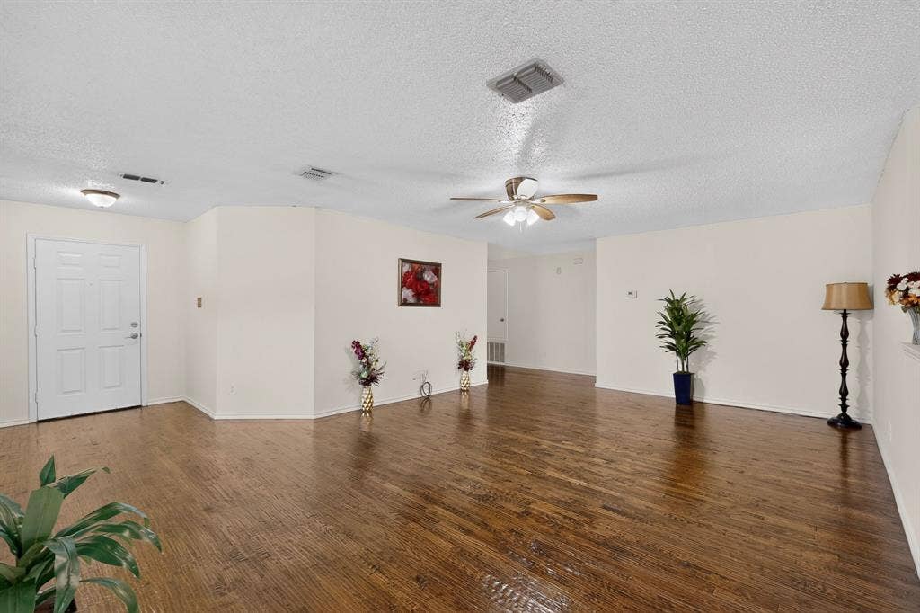 3107 Westview Drive, McKinney, TX 75070 Open-concept room featuring wood-finish flooring, a multi-paneled entry door, and a ceiling-mounted fan with light fixture