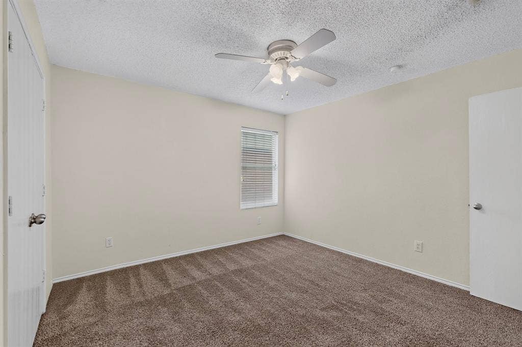 3107 Westview Drive, McKinney, TX 75070 Interior space featuring wall-to-wall carpeting, neutral-toned walls, a central ceiling fan with integrated lighting, and a window with horizontal blinds