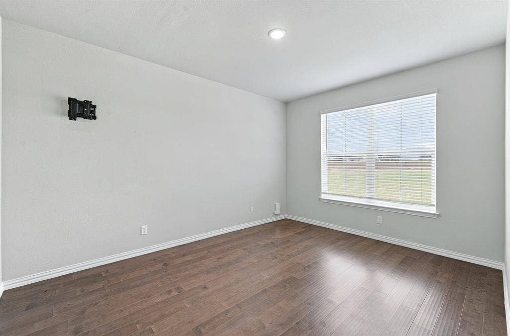 Room featuring wood-finish flooring, neutral wall tones, recessed lighting, and a window with horizontal blinds