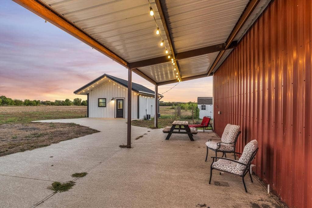 23010 Rosebud Road, Burlington, TX 76519 Covered concrete patio featuring corrugated metal siding and a standing seam metal roof