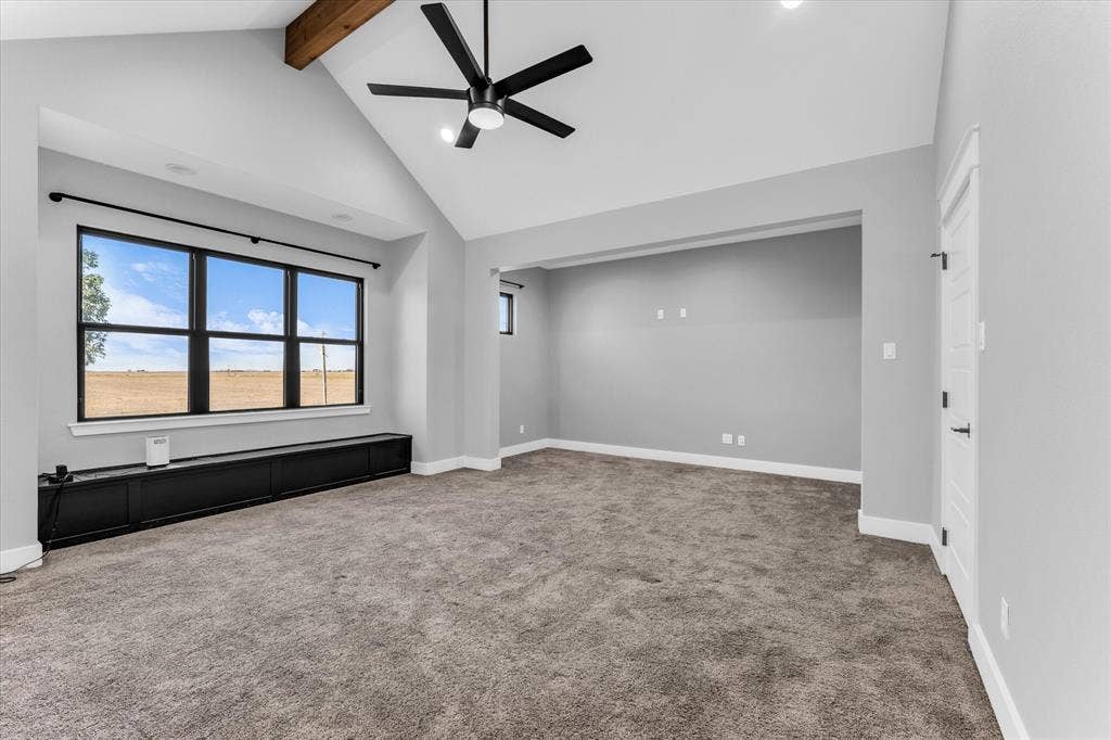 23010 Rosebud Road, Burlington, TX 76519 Vaulted ceiling featuring an exposed wood beam, large windows with black framing, built-in black cabinetry, and a modern ceiling fan