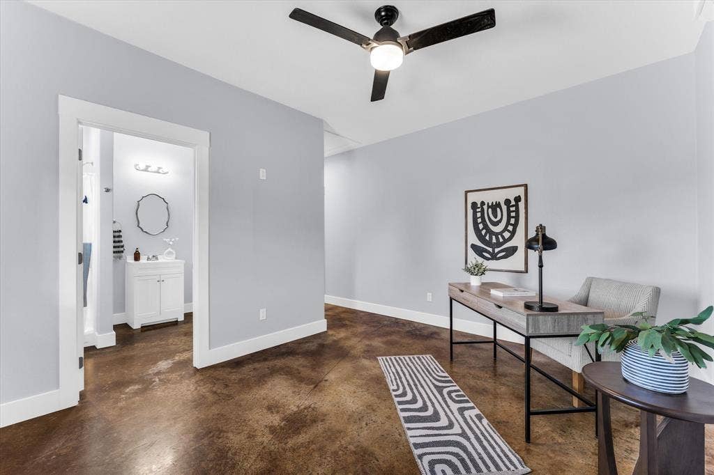 23010 Rosebud Road, Burlington, TX 76519 Stained concrete flooring, matte black ceiling fan with integrated lighting, neutral wall palette, and white door casing