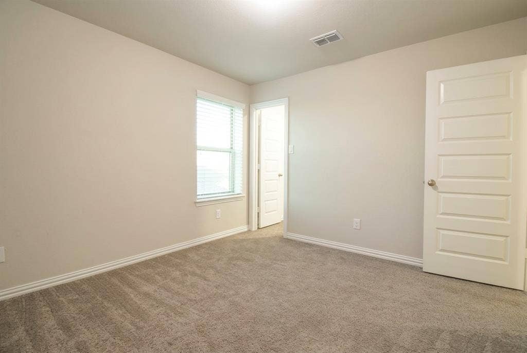 Bedroom3 Neutral interior featuring high-pile wall-to-wall carpeting, four-panel interior doors, and a single-pane window with horizontal blinds