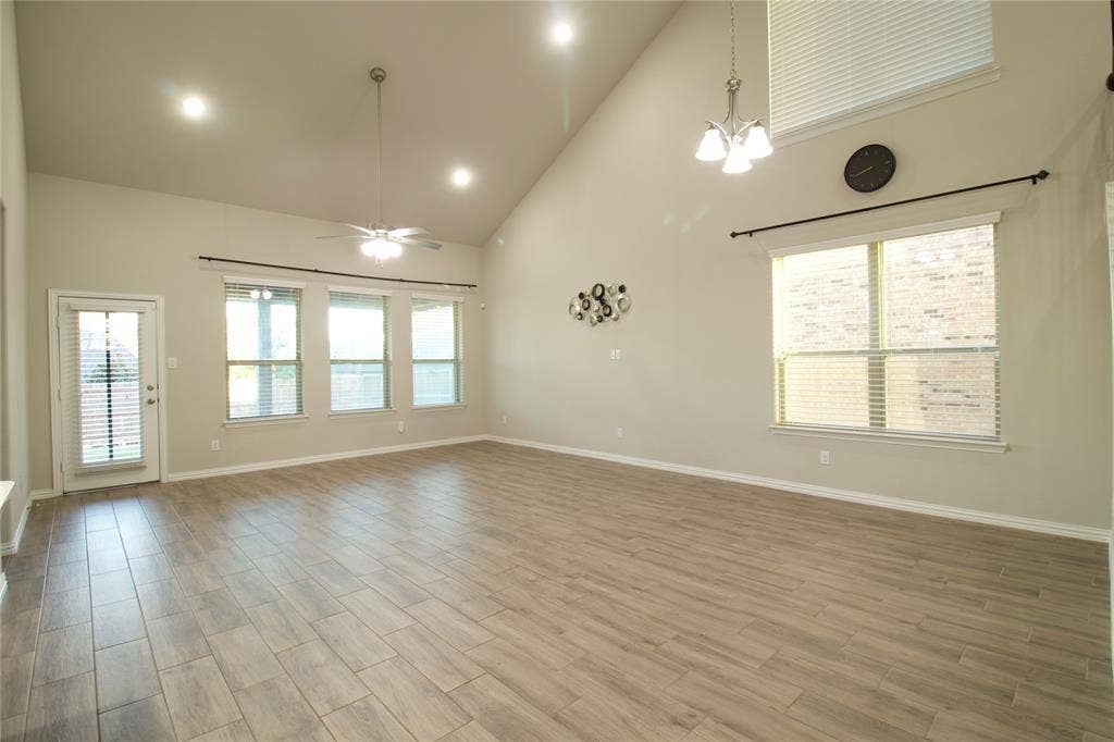 Vaulted ceilings featuring recessed lighting, wood-finish flooring, multi-pane windows, and a dedicated hanging light fixture