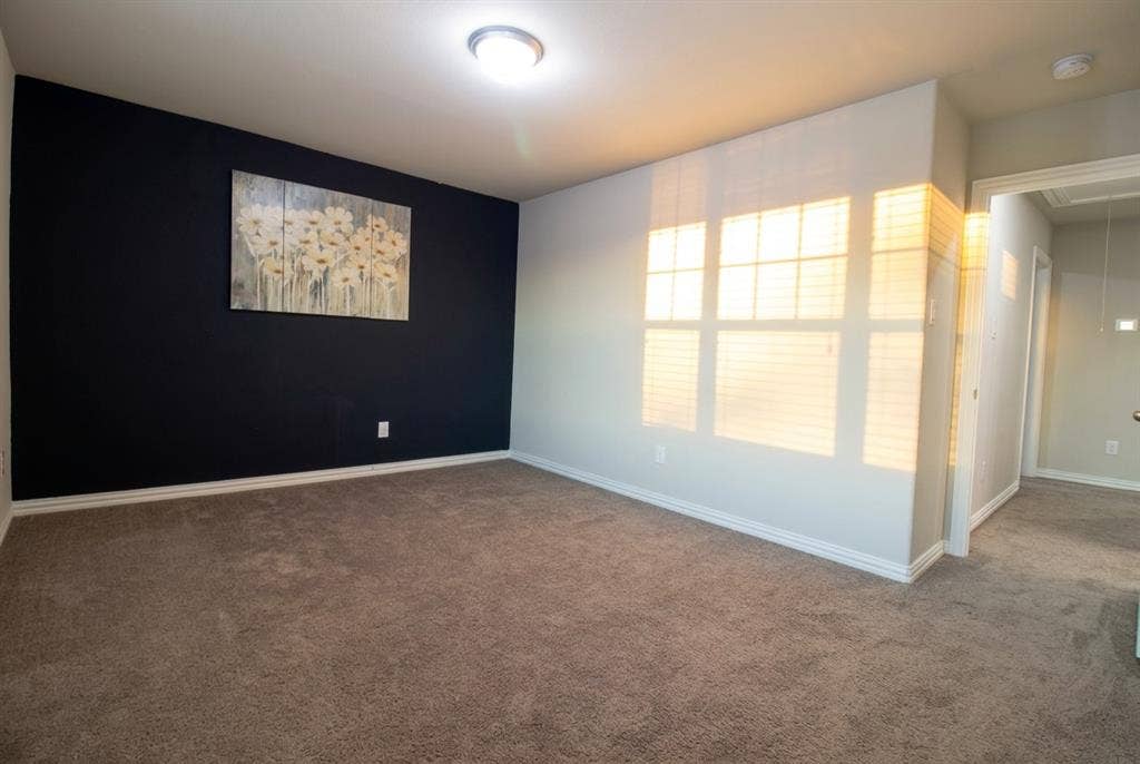 Bed Room 2 featuring neutral wall-to-wall carpeting, a dark accent wall, and multi-pane windows with integrated blinds