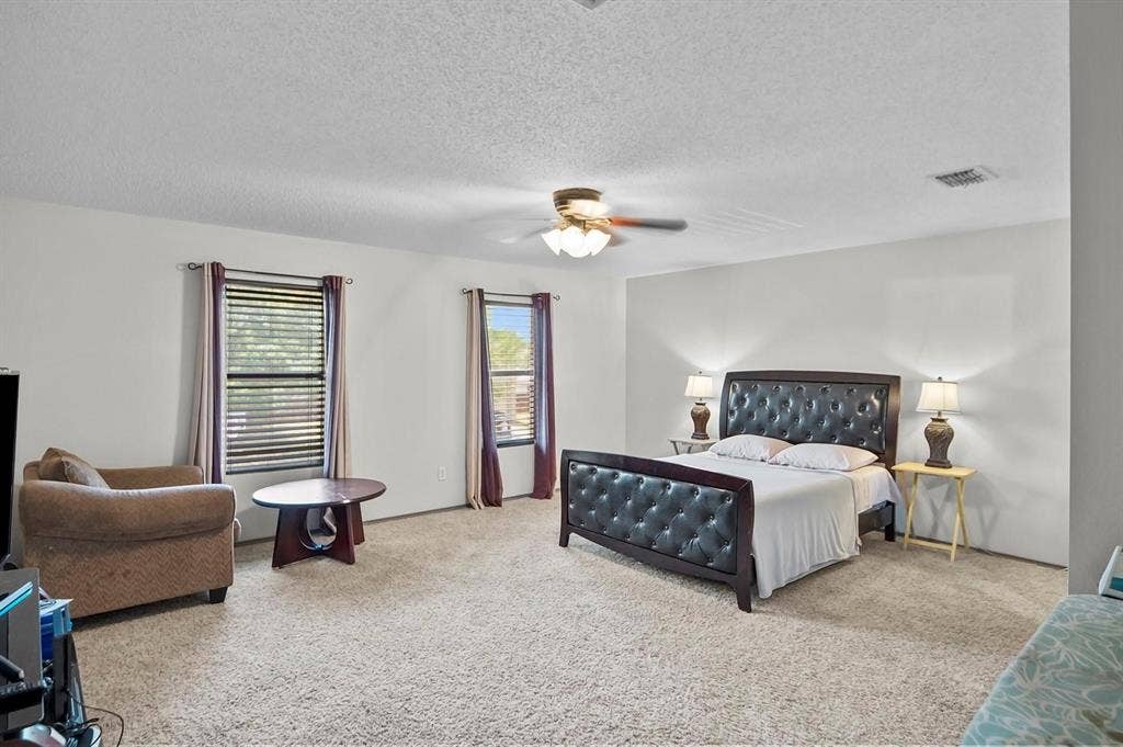 600 Claiborn Lane, Wylie, TX 75098 Spacious room featuring carpeting, two windows with blinds, and a ceiling fan with integrated lighting
