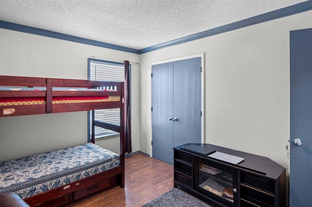 600 Claiborn Lane, Wylie, TX 75098 Wood-finish flooring, dual-panel closet doors, and crown molding featuring a high-contrast finish