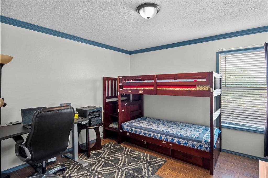 600 Claiborn Lane, Wylie, TX 75098 Room featuring wood-finish flooring, blue painted crown molding, a flush-mount light fixture, and a window with horizontal blinds
