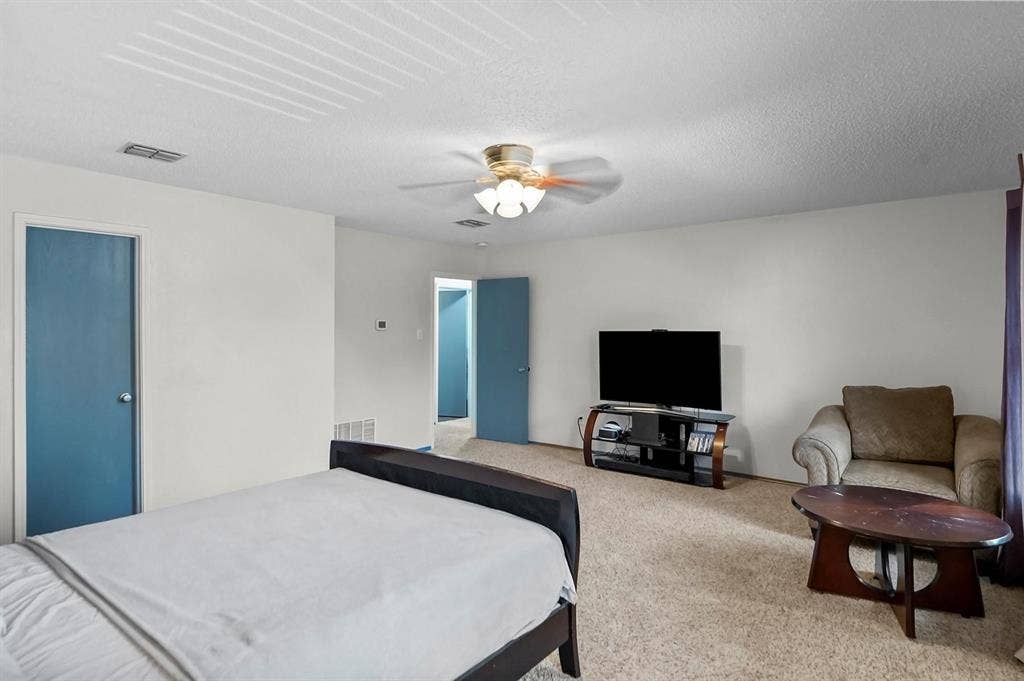 600 Claiborn Lane, Wylie, TX 75098 Room featuring neutral-toned carpeting, a central ceiling fan with integrated light fixture, and solid-core doors with a matte finish