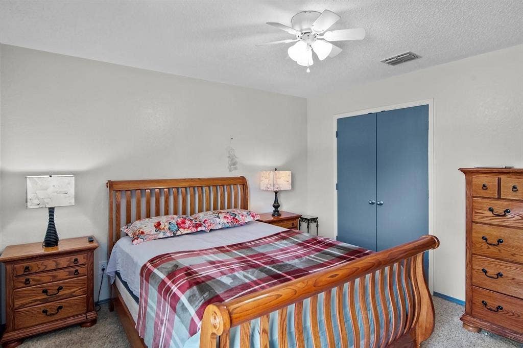 600 Claiborn Lane, Wylie, TX 75098 Bedroom featuring textured ceiling, neutral wall finish, carpeted flooring, and a ceiling fan with integrated lighting