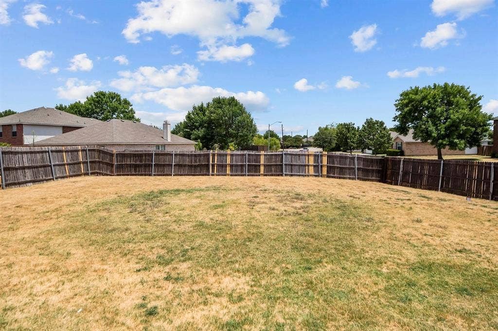 600 Claiborn Lane, Wylie, TX 75098 Expansive backyard featuring a wood privacy fence and mature trees