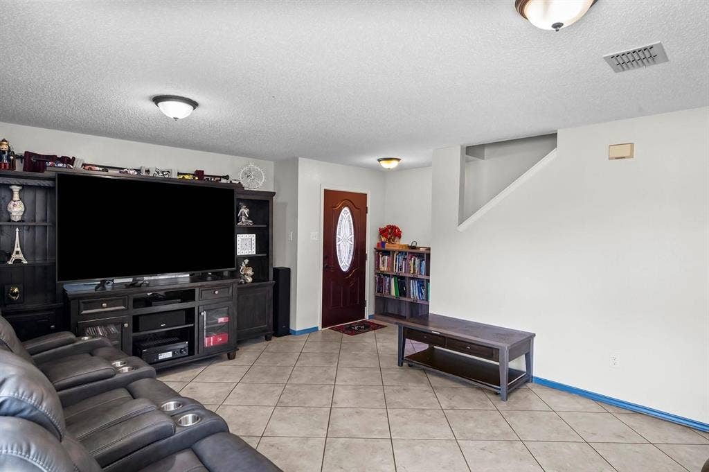 600 Claiborn Lane, Wylie, TX 75098 Large-format tile flooring, built-in dark wood cabinetry, solid wood front door with an oval glass insert, and flush-mount ceiling lighting