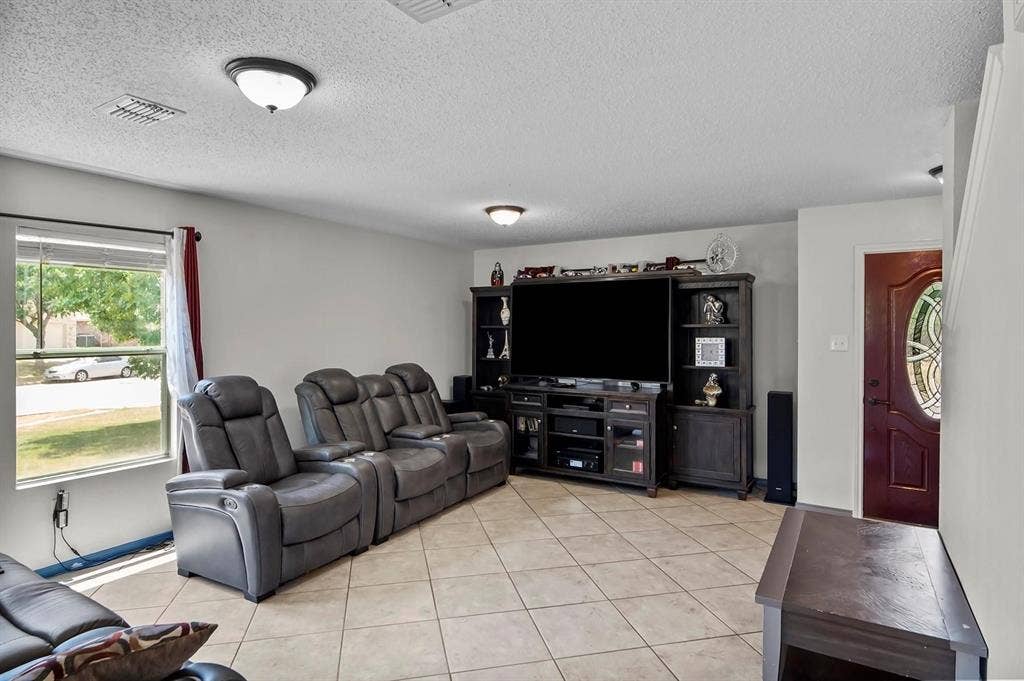 600 Claiborn Lane, Wylie, TX 75098 Living area featuring large-format diagonal tile flooring, dual flush-mount ceiling lights, and an entry door with an oval decorative glass insert