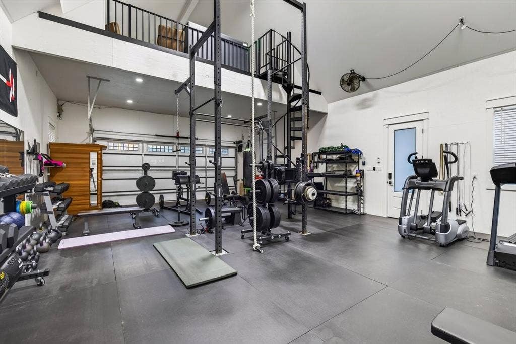 104 Oakbend Trail, Mabank, TX 75147 Oversized garage converted into a fully equipped home gym with high ceilings, rubber flooring, and an upstairs loft.