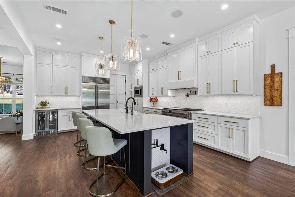 104 Oakbend Trail, Mabank, TX 75147 Beautifully designed kitchen with quartz countertops, custom cabinetry, oversized island, and stainless steel appliances. Yes, that is a pot filler for your pups! Main Residence.
