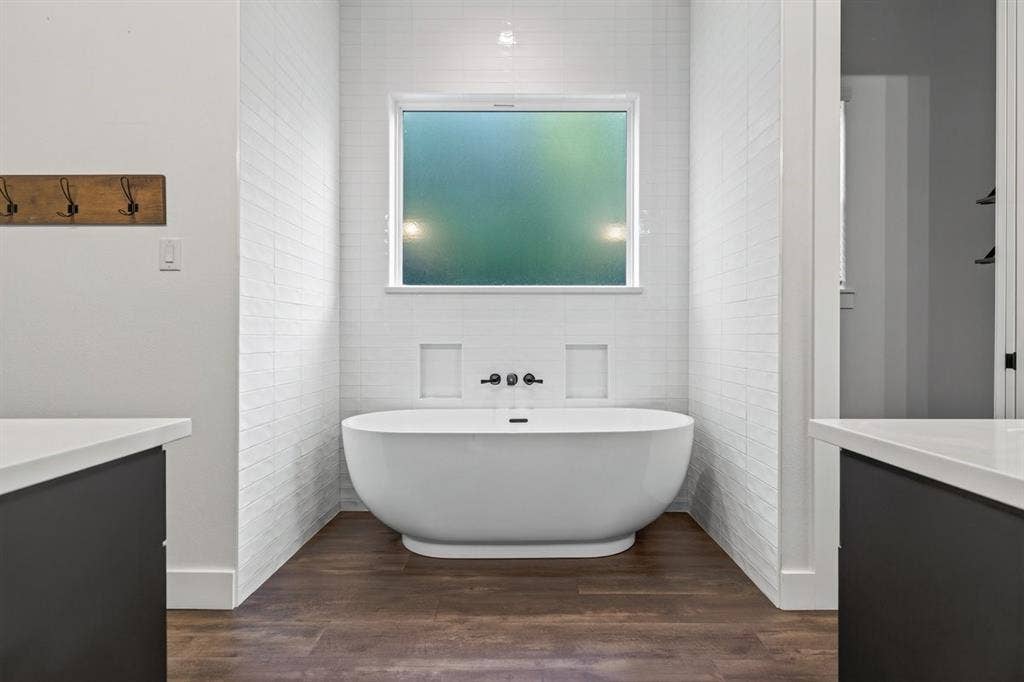 104 Oakbend Trail, Mabank, TX 75147 Freestanding soaking tub surrounded by beautiful tile finishes and a frosted window for natural light. Main Residence.