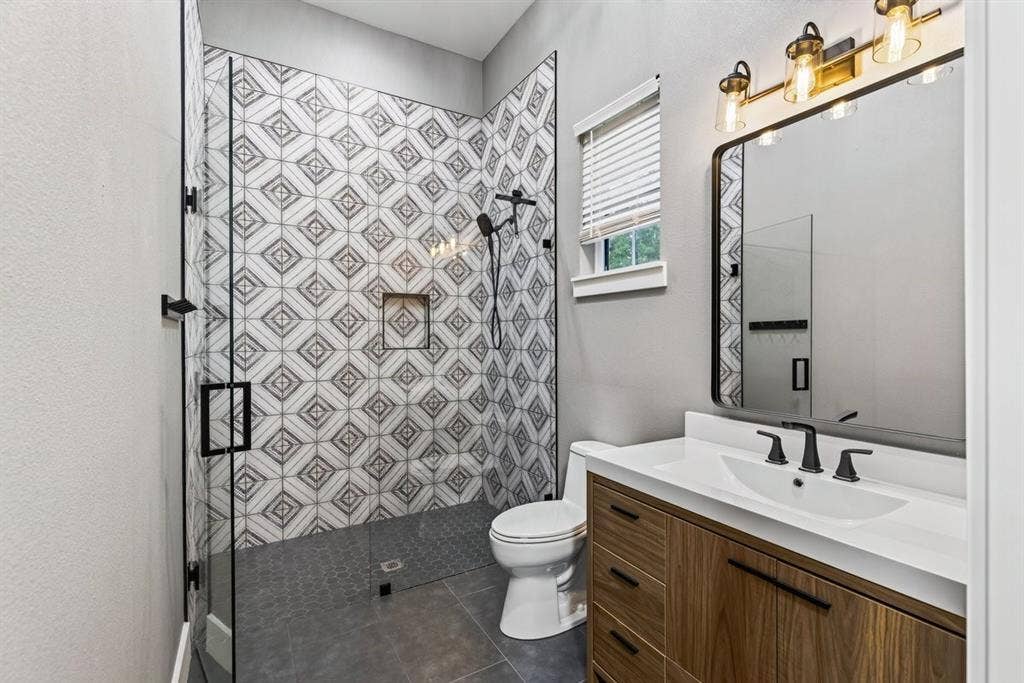 104 Oakbend Trail, Mabank, TX 75147 Beautifully finished bathroom with a walk-in tiled shower, frameless glass enclosure, and modern vanity in garage.