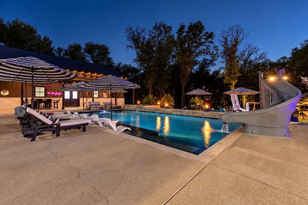104 Oakbend Trail, Mabank, TX 75147 Resort-style pool with waterslide and hot tub, surrounded by multiple outdoor entertaining areas.